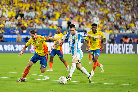 Lionel Messi and Santiago Arias battle for the ball 